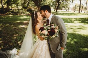 Beautiful couple sharing a romantic kiss with bouquet - the kind of magical moments we help create in Denton, Texas