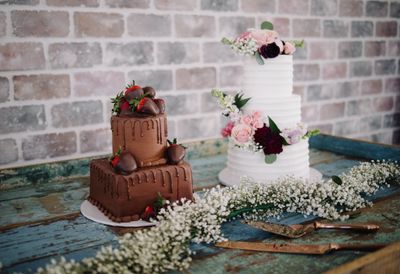 Chocolate-covered strawberries and a floral wedding cake displayed together at a Denton reception dessert table