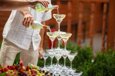 Servers pouring a champagne pyramid of glasses at a wedding reception
