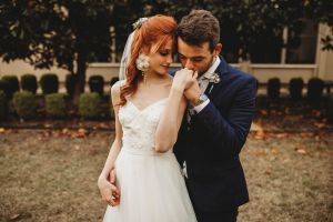 Groom tenderly kissing bride's hand at DFW area wedding - representing the love and care we put into helping plan your perfect Denton wedding