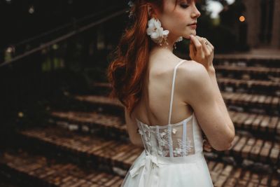 Close-up of a bride's finished wedding hair and makeup, touching her earring